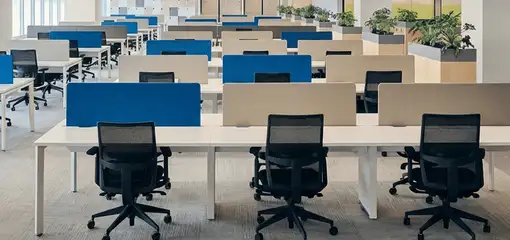 Modern open-plan office space featuring clean workstations, ergonomic chairs, and sanitized carpets provided by professional office cleaning services in Des Moines, IA.